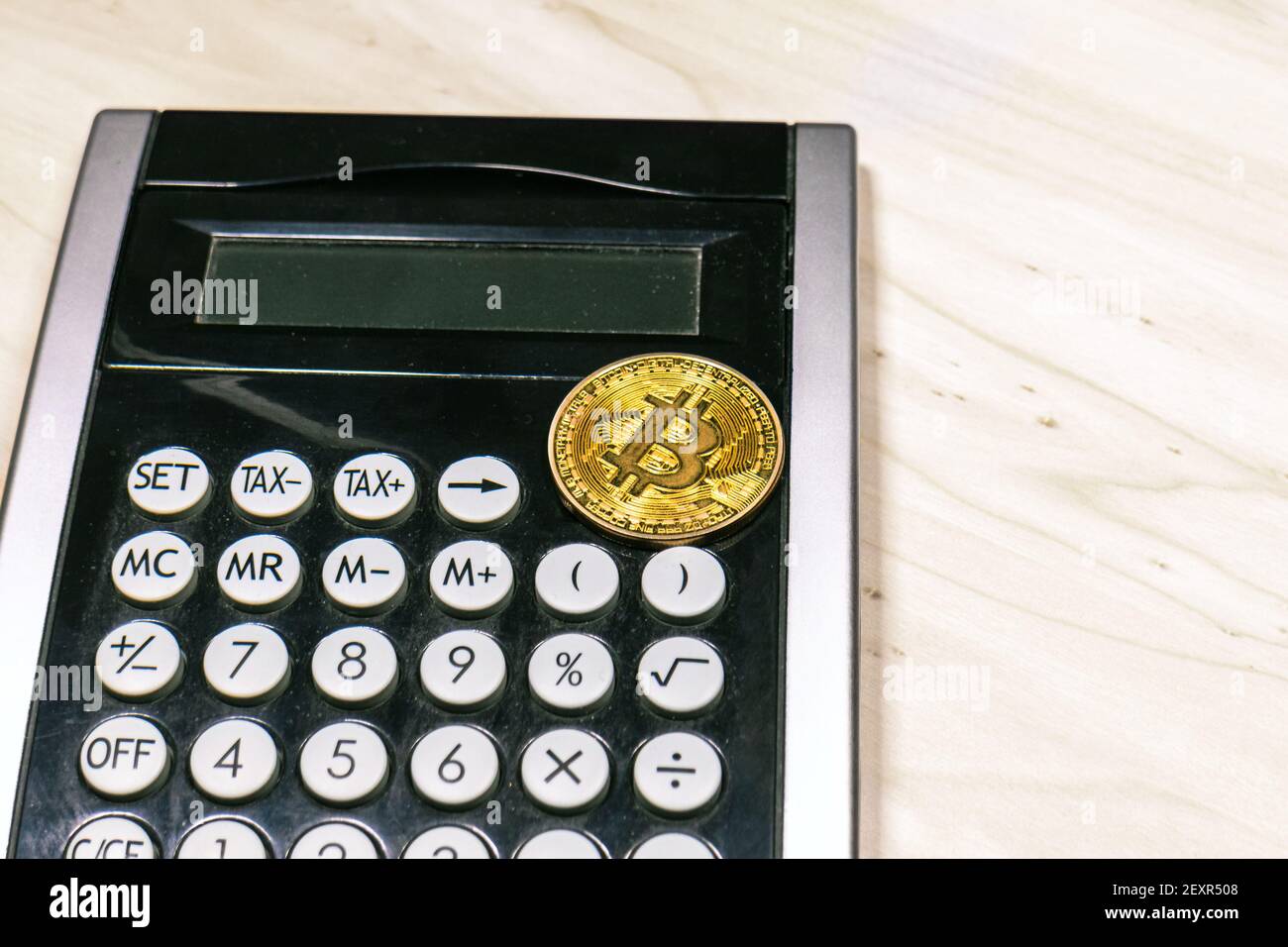 Bitcoin le jour de l'impôt avec la calculatrice sur une table. Banque D'Images