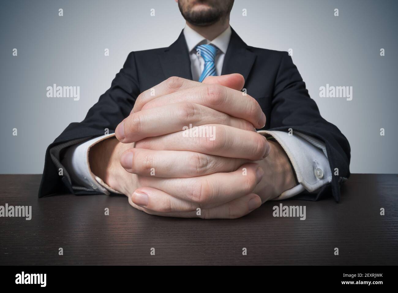 Homme d'affaires assis avec les mains clastées. Concept de négociation et de négociation. Banque D'Images