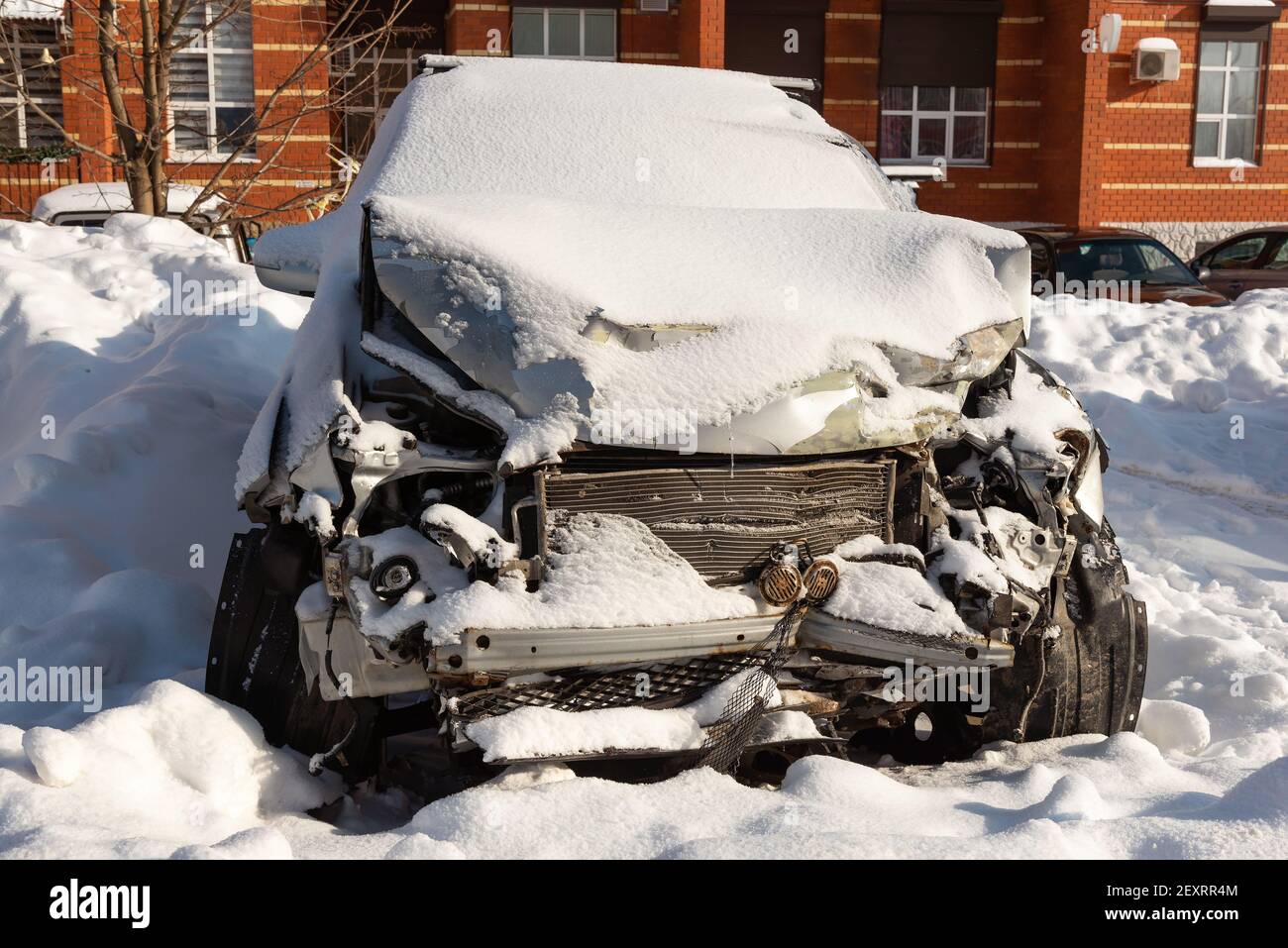 Voiture après un accident de voiture dans un parking, coffre cassé, couvert de neige Banque D'Images