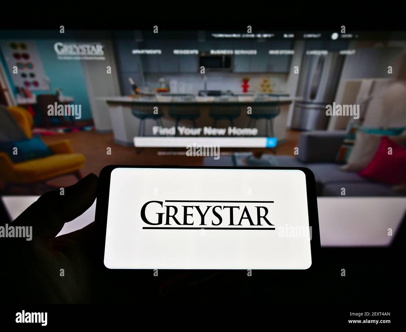 Personne tenant un téléphone mobile avec le logo de la société américaine Graystar Real Estate Partners LLC sur l'écran devant le site Web. Mise au point sur l'affichage du téléphone. Banque D'Images