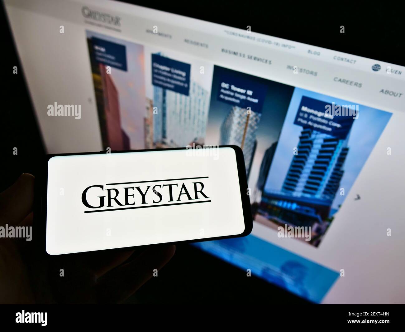 Personne tenant le téléphone portable avec le logo de la compagnie d'appartement américaine Graystar Real Estate Partners à l'écran en face de la page Web. Concentrez-vous sur l'affichage du téléphone portable. Banque D'Images