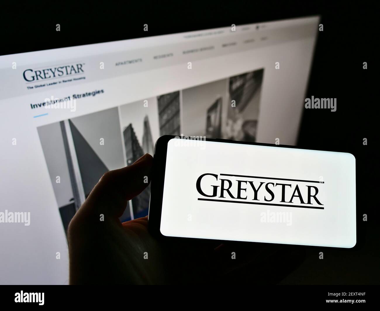 Personne tenant un smartphone avec le logo de la société immobilière américaine Graystar Real Estate Partners LLC sur l'écran devant le site Web. Mise au point sur l'affichage du téléphone. Banque D'Images