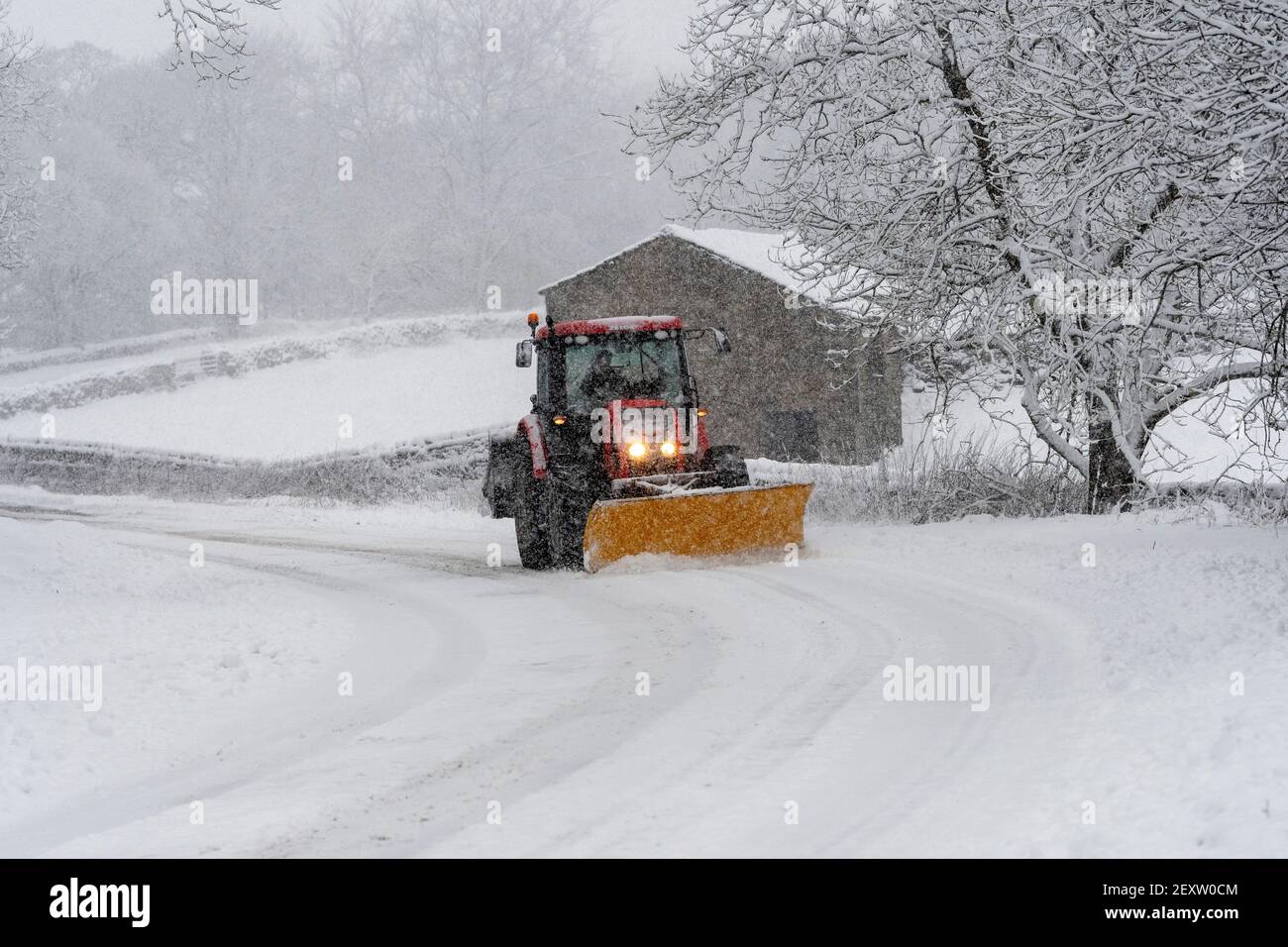 Tracteur avec chasse-neige déblaçant l'A684 après une forte chute de neige, Hawes, North Yorkshire, Royaume-Uni. Banque D'Images