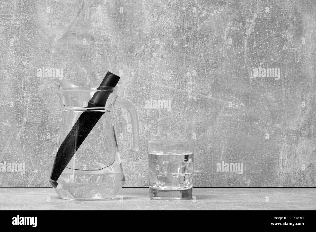 Bâton de filtre à eau au charbon de bambou et verre d'eau. Le charbon de bambou naturel est un purificateur puissant qui rafraîchit l'eau du robinet Banque D'Images