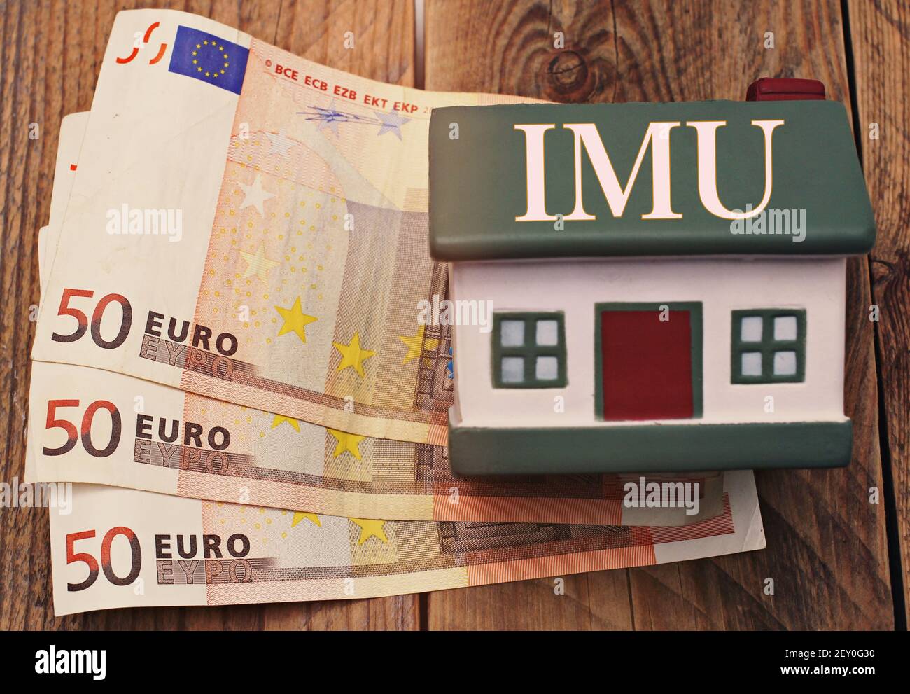 Maison avec des billets en euros avec le signe 'IMU' taxe italienne Banque D'Images