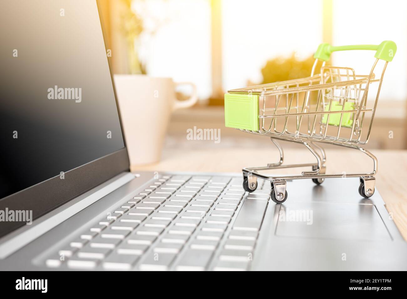 achat et livraison en ligne. Petit chariot de shopping debout sur le clavier d'ordinateur portable. Panier avec ordinateur portable que la boutique en ligne pour acheter Banque D'Images