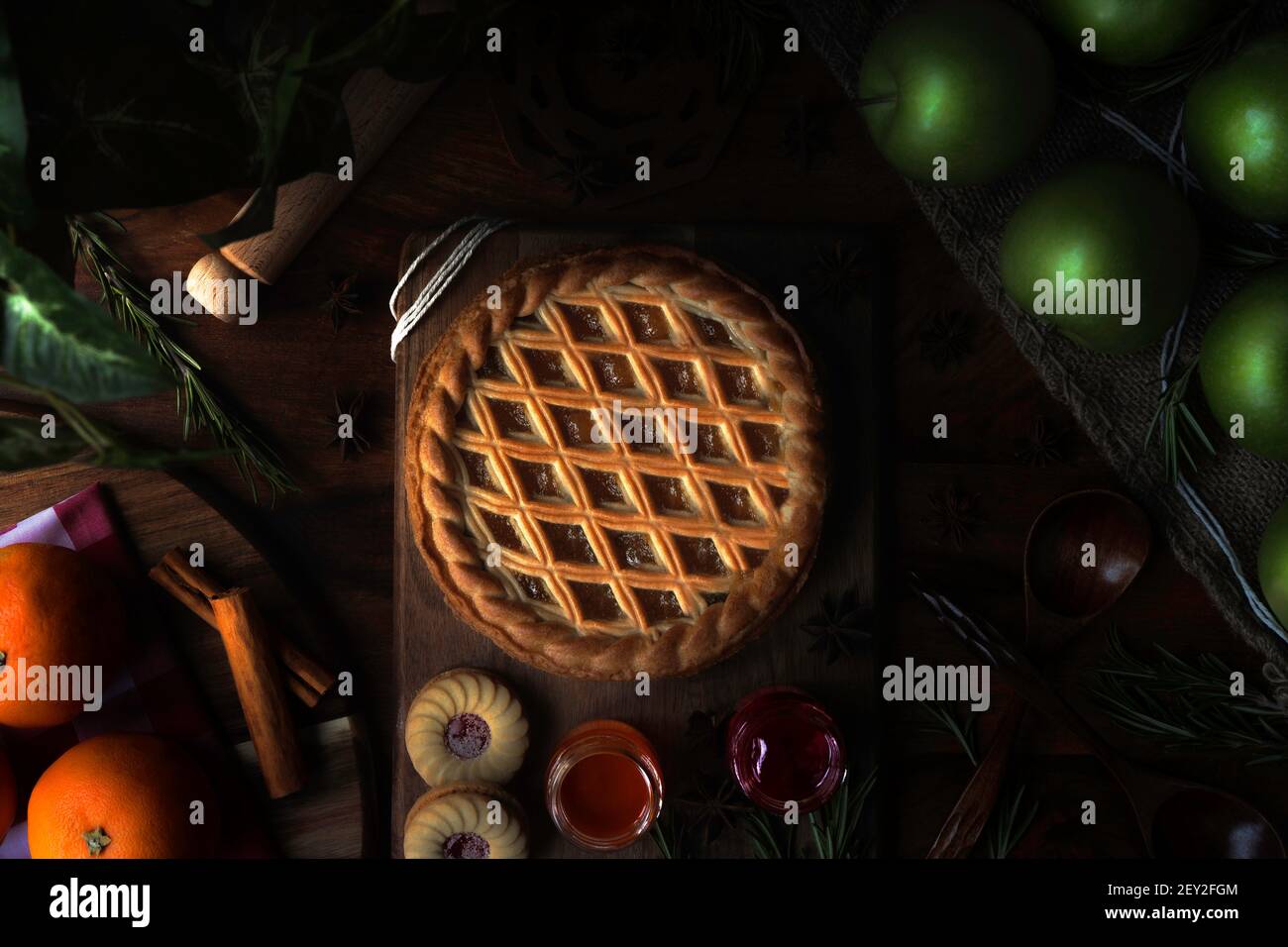 Tarte aux pommes fraîchement cuite au soleil avec ustensiles et une variété d'ingrédients. Banque D'Images