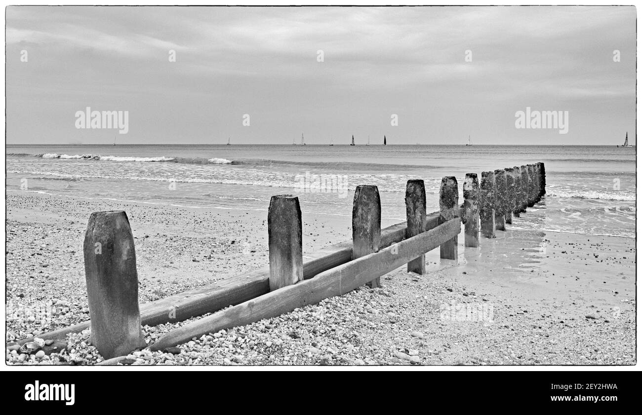 Beaux-arts noir et blanc image-à travers les groynes à la plage de Shoreham Banque D'Images