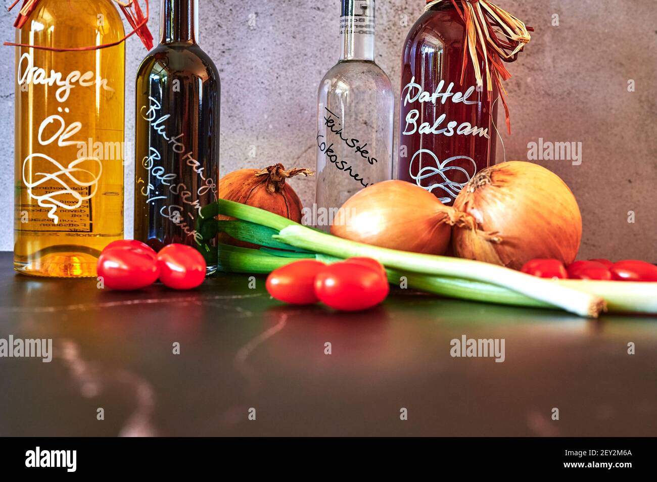 Berlin, Allemagne - 5 mars 2021 : diverses huiles telles que l'huile balsamique de date et l'huile d'orange avec des ingrédients frais. Banque D'Images
