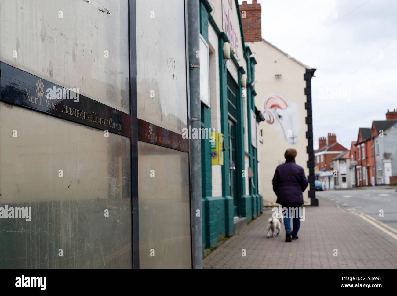 Ibstock, Leicestershire, Royaume-Uni. 5 mars 2021. Une femme marche un chien après un arrêt de bus. Le nord-ouest du Leicestershire a le taux de coronavirus le plus élevé en Angleterre, selon les derniers chiffres de Santé publique Angleterre. Credit Darren Staples/Alay Live News. Banque D'Images