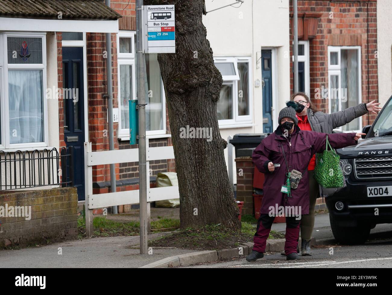 Coalville, Leicestershire, Royaume-Uni. 5 mars 2021. Les femmes avec des revêtements faciaux grêle un bus. Le nord-ouest du Leicestershire a le taux de coronavirus le plus élevé en Angleterre, selon les derniers chiffres de Santé publique Angleterre. Credit Darren Staples/Alay Live News. Banque D'Images