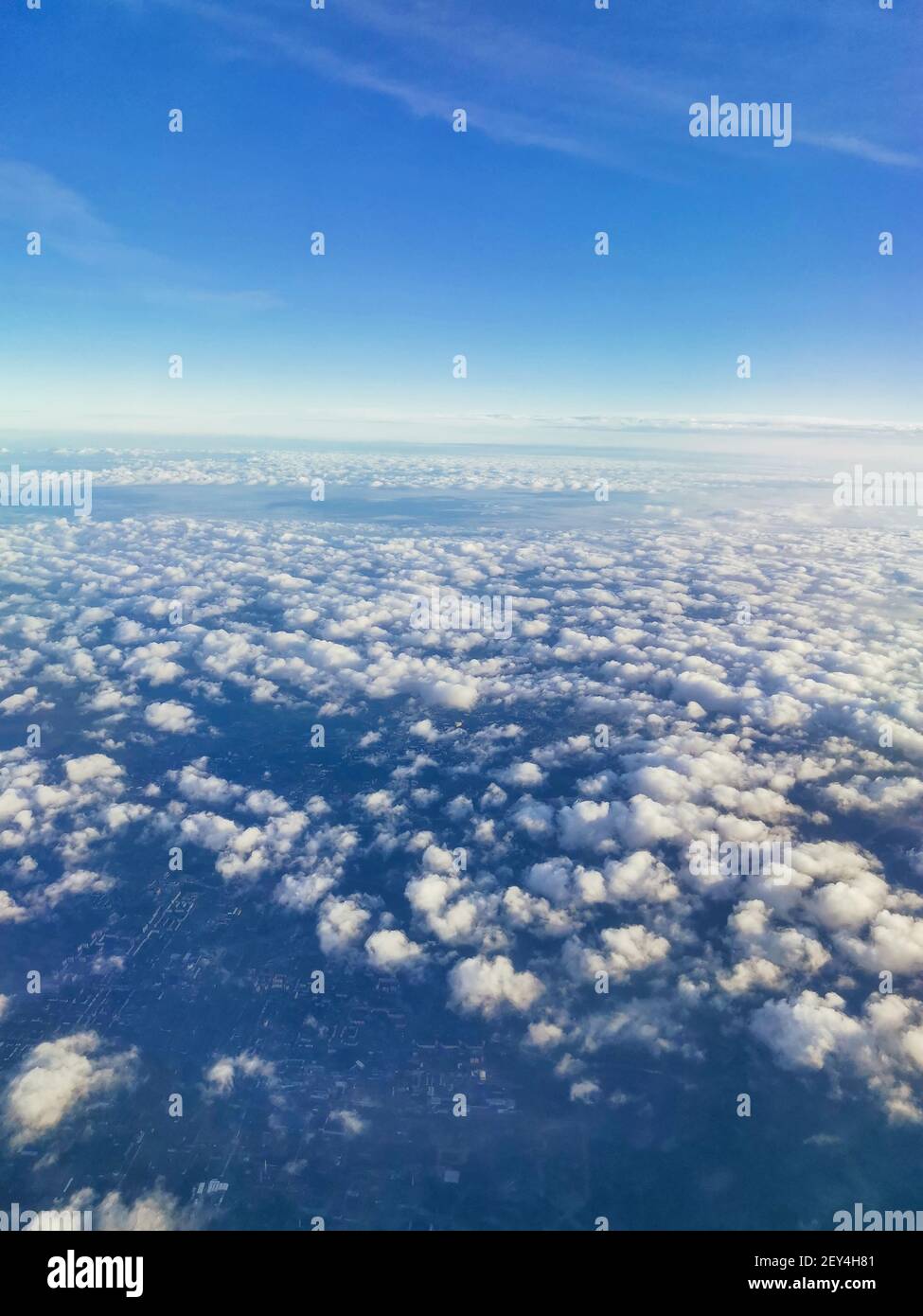 Concept de voyage. Une belle vue depuis un avion sur des nuages blancs volumineux et moelleux sur le fond d'un ciel bleu vif, gratte-ciel de la ville belo Banque D'Images