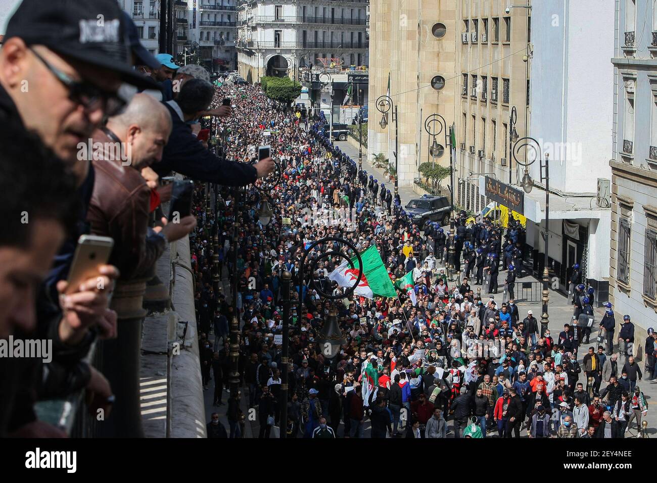 Alger, Algérie. 05e mars 2021. Les manifestants algériens lèvent un drapeau national lorsqu'ils marchent au cours d'une manifestation anti-gouvernementale dans le cadre d'un nouvel élan aux manifestations de masse, communément appelées le mouvement Hirak, qui ont poussé Abdelaziz Bouteflika, le dirigeant de longue date, à quitter ses fonctions en avril 2019. Credit: Farouk Batiche/dpa/Alay Live News Banque D'Images
