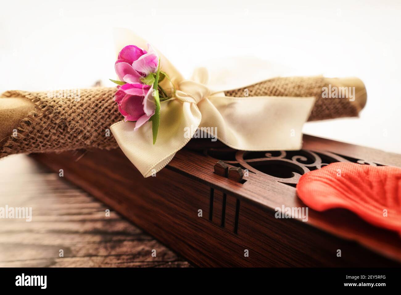 Une boîte en bois ornée de parchemin enveloppée de tissu et fleurs Banque D'Images