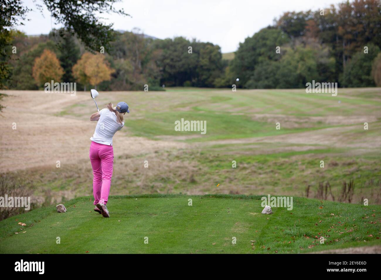 Une golfeuse portant un pantalon rose est vêtue d'un t-shirt parcours de golf Banque D'Images