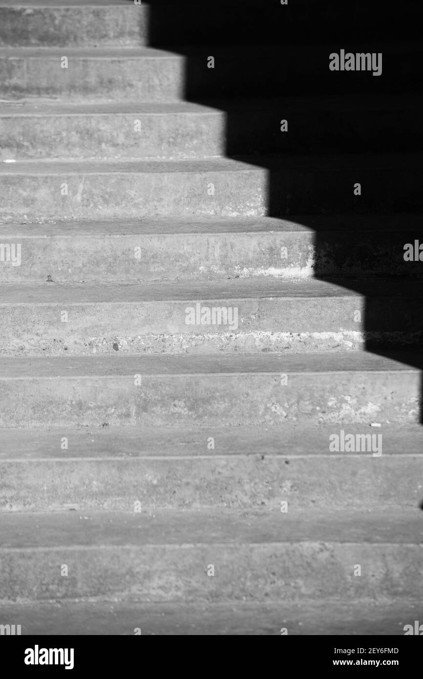 ombres projetées sur les escaliers extérieurs en ciment par la lumière du soleil de l'après-midi dans le soleil de jour créant l'illusion optique de l'obscurité vide angles ou ondulation Banque D'Images