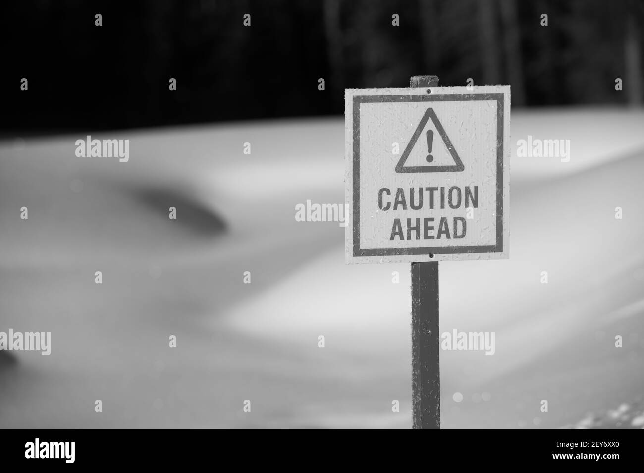 attention, signe triangle avec point d'exclamation dans la neige noire et blanche en arrière-plan avertissant de la glace mince devant l'étang sur le terrain de golf en hiver Banque D'Images