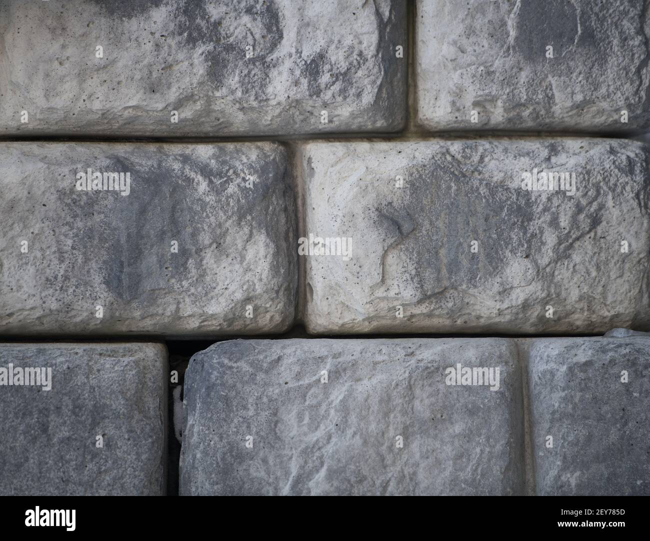 pierres faites par l'homme pierres en forme de briques en gros plan de pierre de pierre ou mur de brique empilé ensemble bâtiment extérieur ou paysage arrière-plan horizontal Banque D'Images