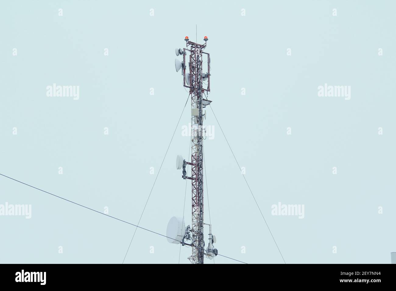 Antenne de réseau mobile de la station de base sur un toit d'un immeuble résidentiel contre un ciel gris. 3g, 4g, 5 g. Photo avec espace vide pour le texte et le design. Banque D'Images