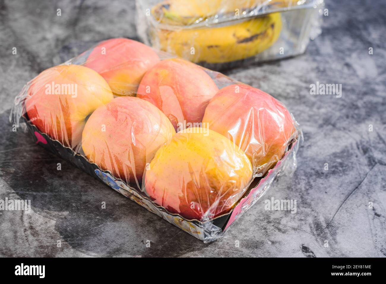Fruits emballés dans du plastique inutile dans un supermarché Banque D'Images