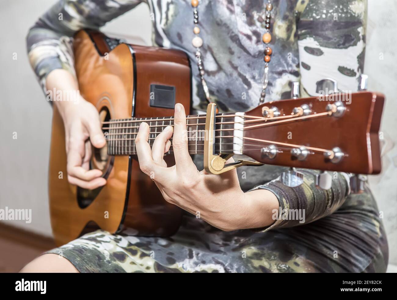 Femme en robe joue une guitare acoustique. Gros plan, détail. Banque D'Images