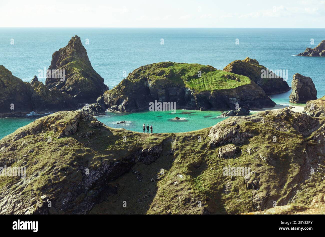 Les marcheurs de Ridge regardent vers le bas sur les vacanciers en profitant d'une journée ensoleillée à Kynance Cove sur la péninsule de Lizard à Cornwall, au Royaume-Uni Banque D'Images