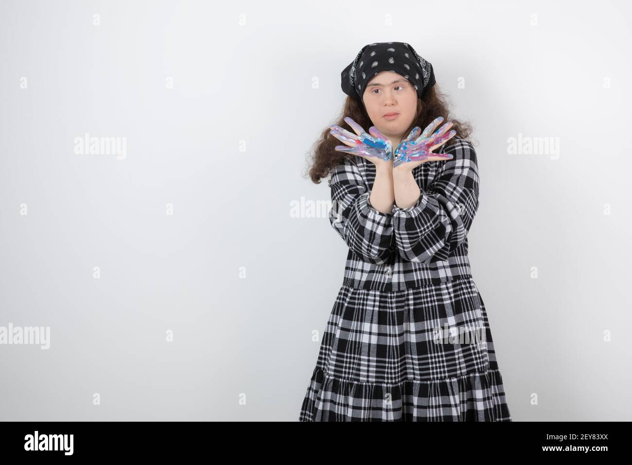 Jeune fille avec le syndrome de Down montrant des couleurs sur fond blanc Banque D'Images