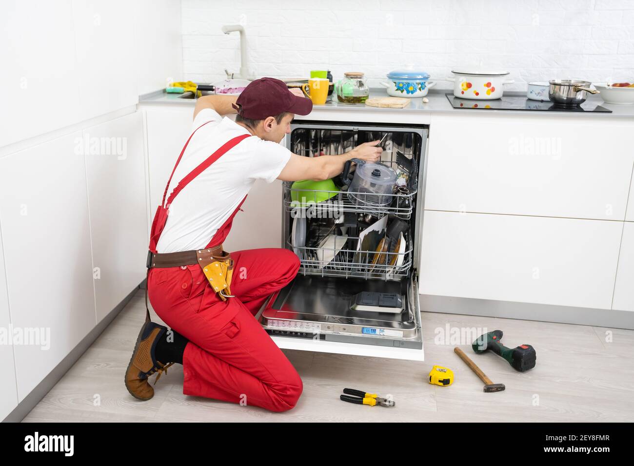 Réparation de lave-vaisselle. Le maître est venu à la maison et est en  train de réparer le lave-vaisselle Photo Stock - Alamy