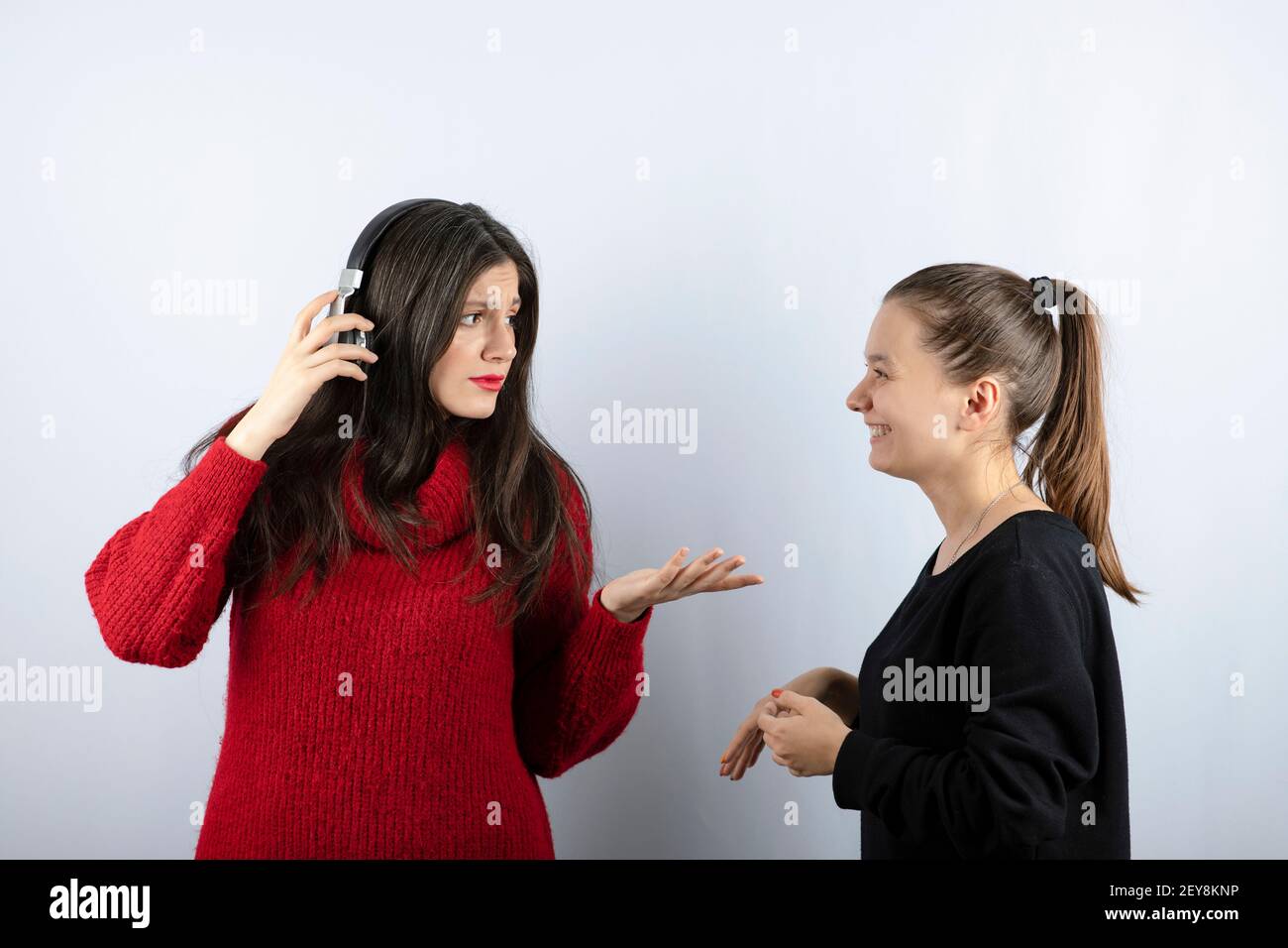 Brunette femme dans un casque regardant une jeune fille souriante Banque D'Images