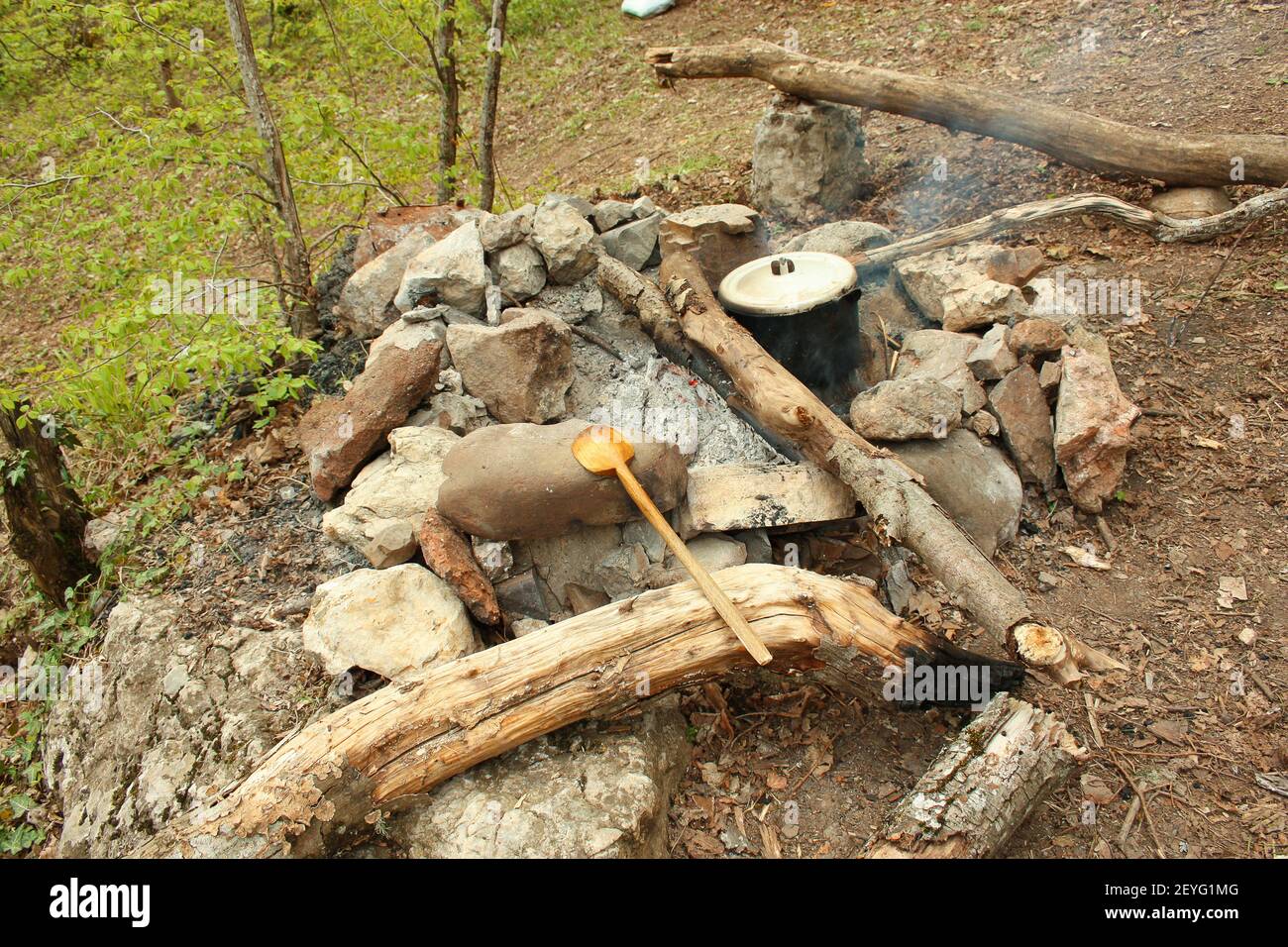 Cuisson sur le feu, marmite sur le feu, cuillère en bois sur les pierres, nourriture touristique Banque D'Images