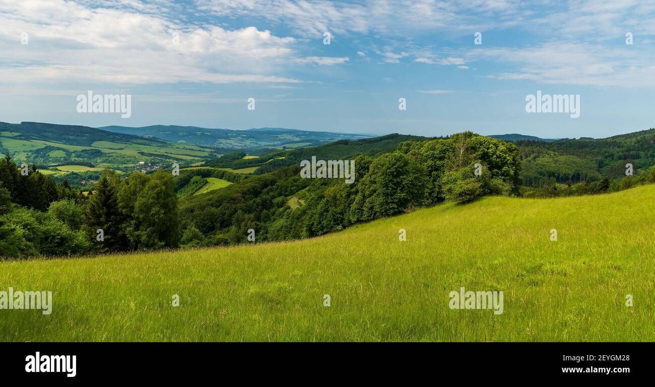 Paysage vallonné avec des prairies, peu de villages, forêt, collines et ciel bleu avec des nuages - vue de prairies au-dessus de Nedasova Lota village à Bile Karpaty Mo Banque D'Images