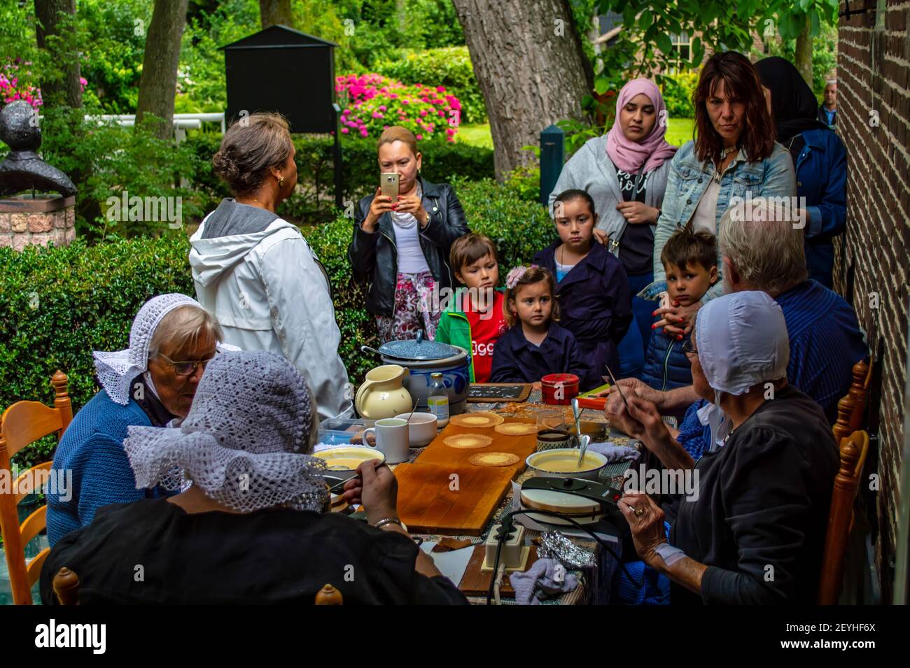 Giethoorn, pays-Bas - 6 juillet 2019 : un groupe de touristes non identifiés assistent à un atelier de stropgaufre dans le village de Giethoorn. Banque D'Images