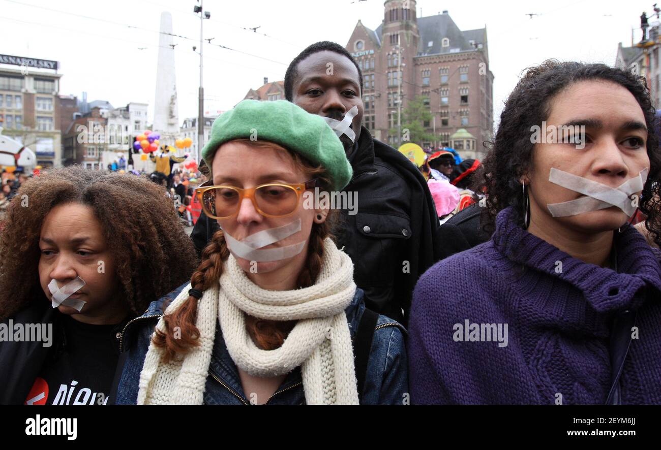 Les manifestants avec une bande sur leur bouche et portant des t-shirts disant «Black Pete is Rascisme» tournent le dos à la procession lors de l'entrée traditionnelle de Saint Nicolas à Amsterdam, dans une protestation contre la figure traditionnelle Zwarte Piet (Black Pete), le 17 novembre 2013. Zwarte Piet est le compagnon de Saint Nicolas lors d'une fête annuelle célébrée le soir du 5 décembre. Il a été annoncé en octobre 2013 que l'Organisation des Nations Unies, sous l'autorité du Haut Commissaire aux droits de l'homme, enquêtait sur la question de savoir si Zwarte Piet est un stéréotype raciste. (Photo de Paulo Amorim/Sipa U Banque D'Images