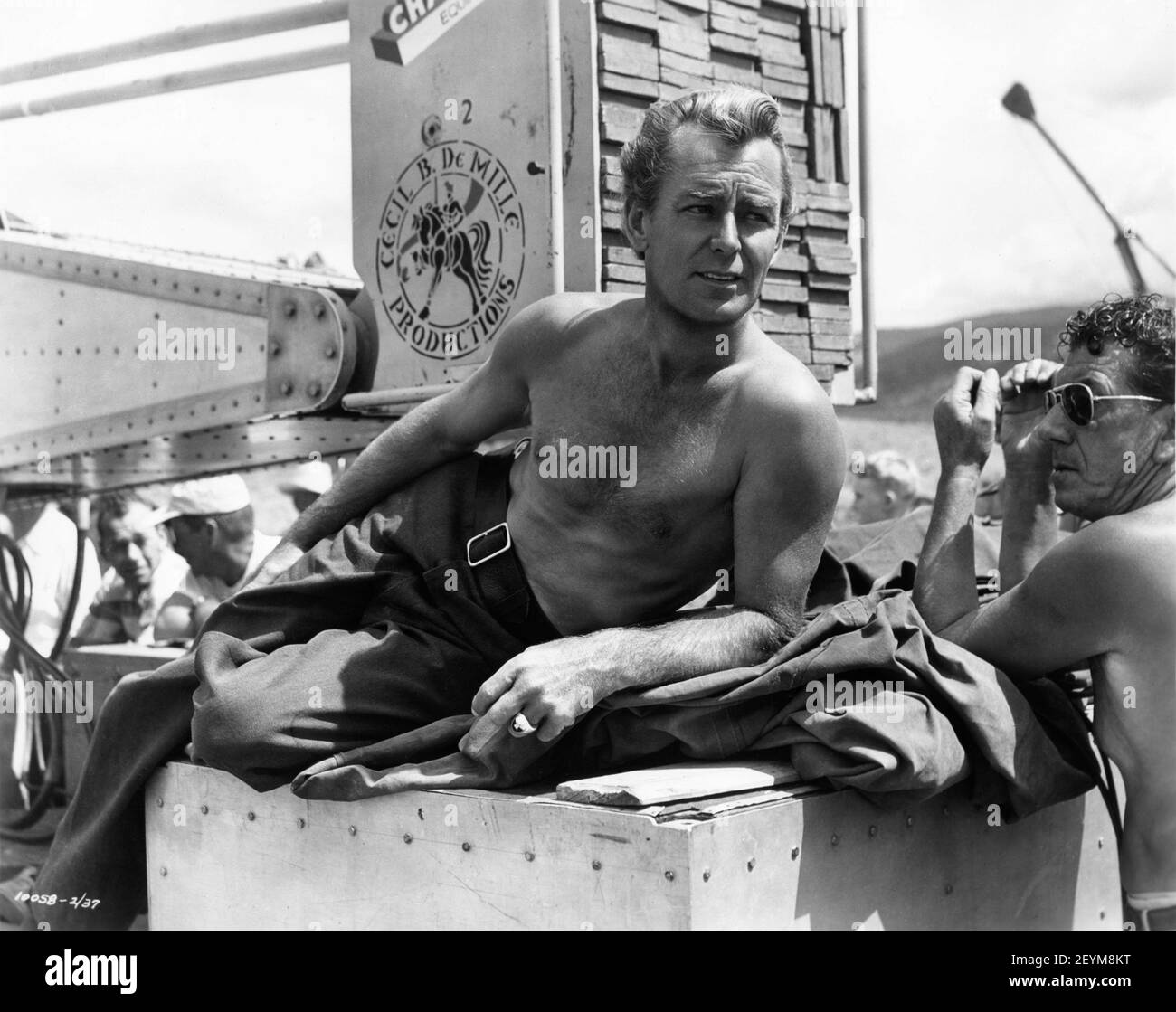 ALAN LADD sur le lieu de tournage Candid avec film Crew et Cecil B. DeMille Productions Camera Crane pendant le tournage de SHANE 1953 réalisateur GEORGE STEVENS basé sur le roman de Jack Shaeffer costumes Edith Head Paramount Pictures Banque D'Images