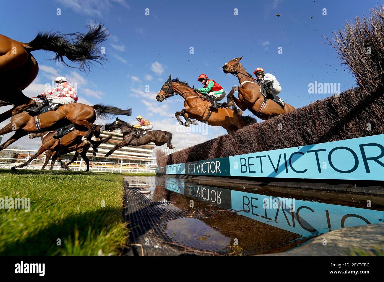 David Noonan à cheval Umbrigado (farside, casquette jaune) Éclair le saut à l'eau avant de continuer à gagner le BetVictor Greatwood Gold Cup Handicap Chase à l'hippodrome de Newbury. Date de la photo: Samedi 6 mars 2021. Banque D'Images