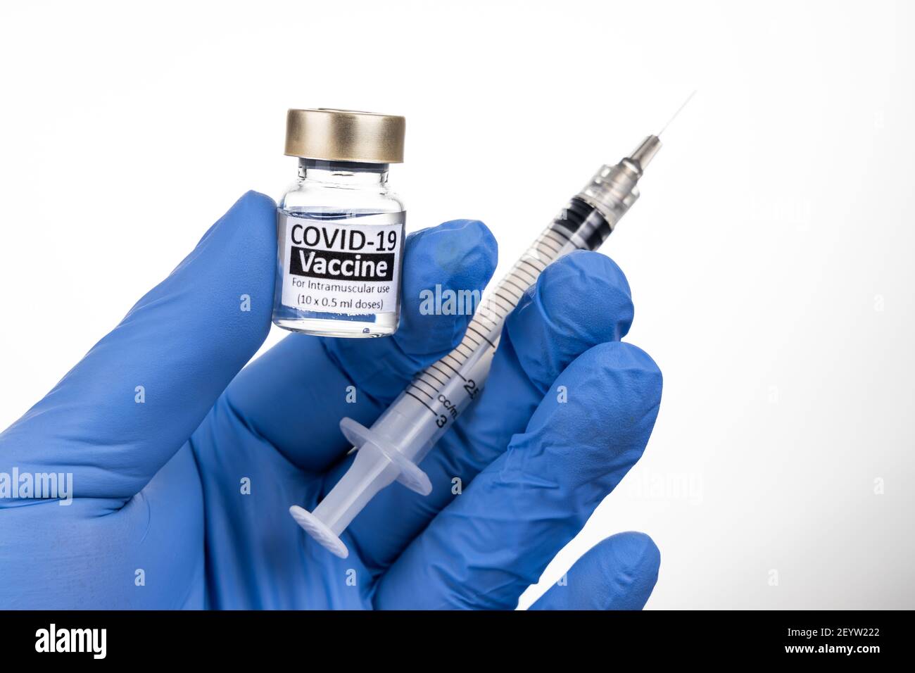 Gros plan de la main avec un gant chirurgical tenant un flacon de vaccin Covid-19 Banque D'Images