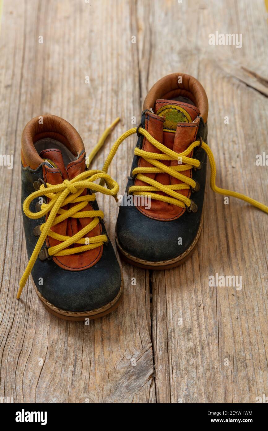 Cache-chaussettes de petite taille pour bébé garçon, vue rapprochée.  Chaussures pour enfant en cuir bleu avec lacets jaunes non noués sur  parquet Photo Stock - Alamy