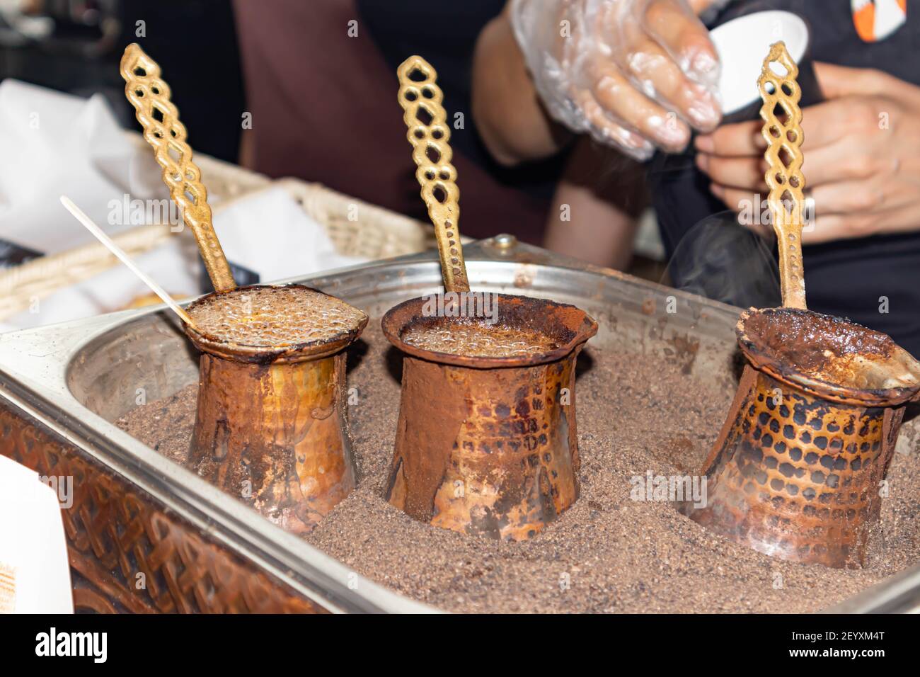 Café aromatique brassé dans du sable chaud - café turc braquant dans la glace. Banque D'Images