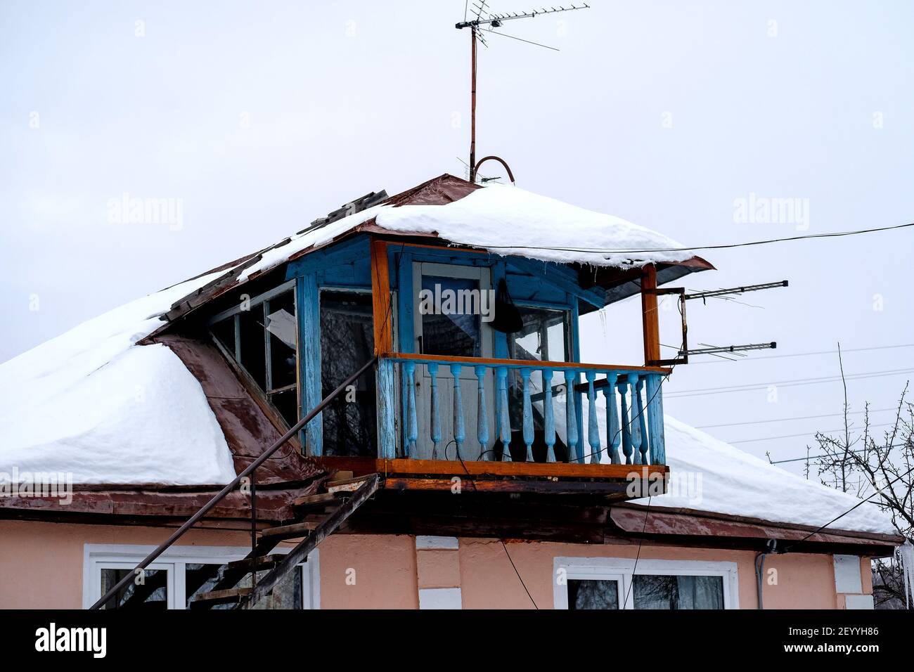 Bashkiria, Russie - 01.30.2021: Ancien balcon décré ouvert dans le village russe. Superstructure sur la maison. Ciel d'hiver flou tout autour. Banque D'Images