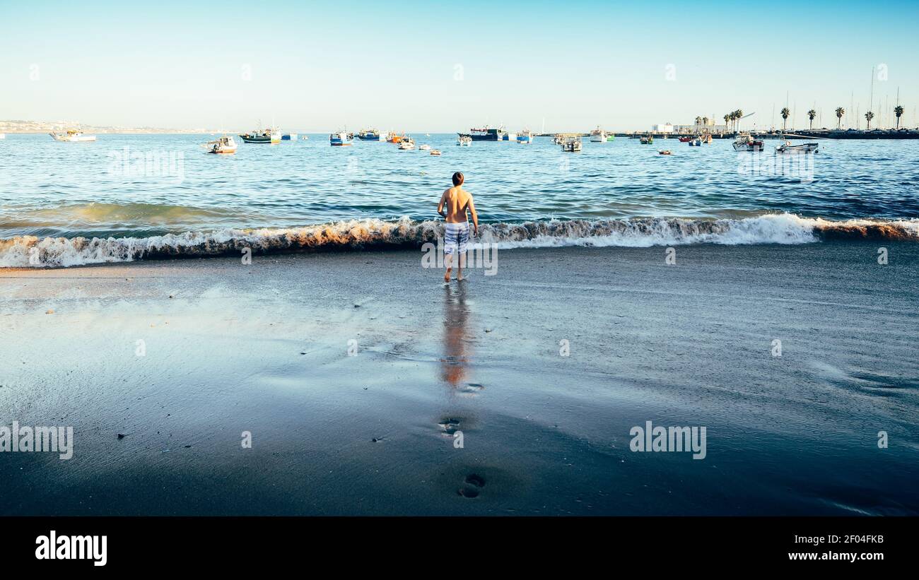 Une personne seule sur la plage par une journée ensoleillée à Cascais, Portugal Banque D'Images