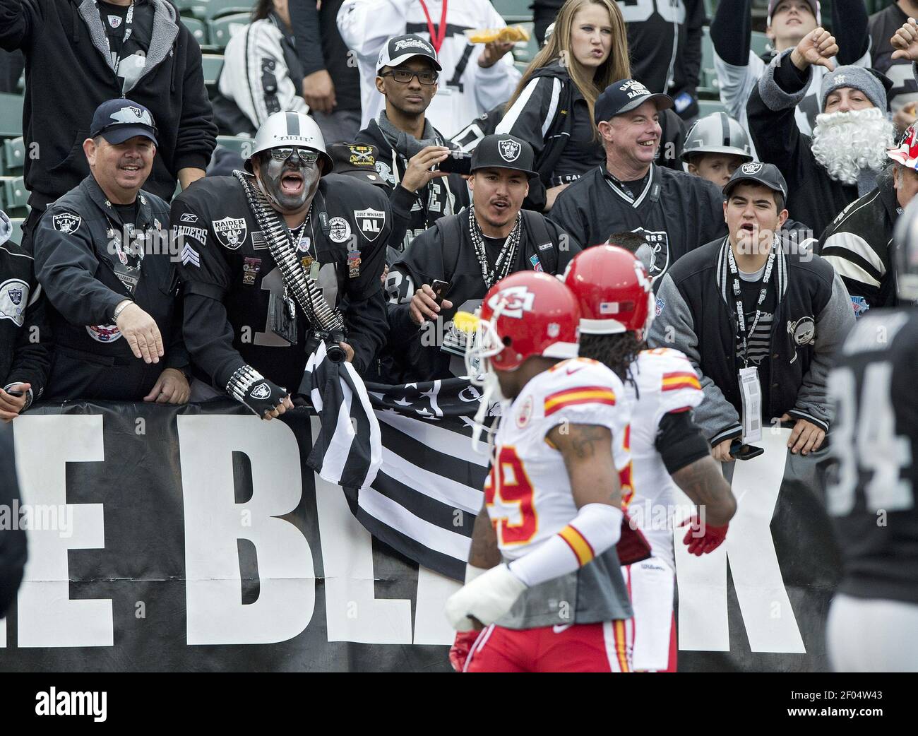 Les fans des Raiders d'Oakland dans le trou noir font part à des chefs de Kansas City de la sécurité forte Eric Berry (29) et de la sécurité libre Kendrick Lewis (23) alors qu'ils entrent dans le champ pour les échauffements avant le match à O.co Coliseum à Oakland, Californie, le dimanche 16 décembre 2012. (Photo de John Sleezer/Kansas City Star/MCT/Sipa USA) Banque D'Images