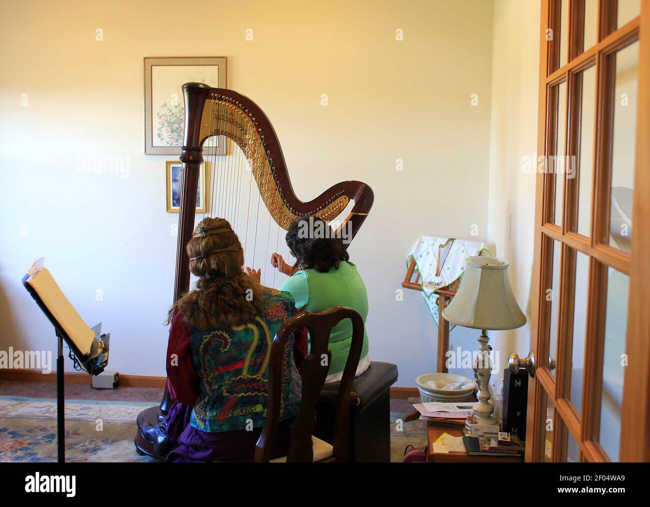 Mia Strayer, 21 ans, centre, qui est malvoyants et a la paralysie  cérébrale, pratique sur une harpe de concert avec son instructeur Nanette  Felix, à gauche, pendant une leçon dans la maison