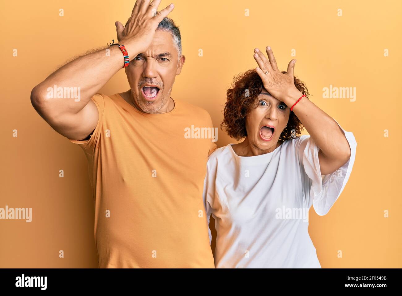 Beau couple d'âge moyen ensemble portant des vêtements décontractés surpris avec la main sur la tête pour l'erreur, souvenez-vous de l'erreur. oublié, mauvais concept de mémoire. Banque D'Images Beau couple d'âge moyen ensemble portant des vêtements décontractés surpris avec la main sur la tête pour l'erreur, souvenez-vous de l'erreur. oublié, mauvais concept de mémoire. Banque D'Images