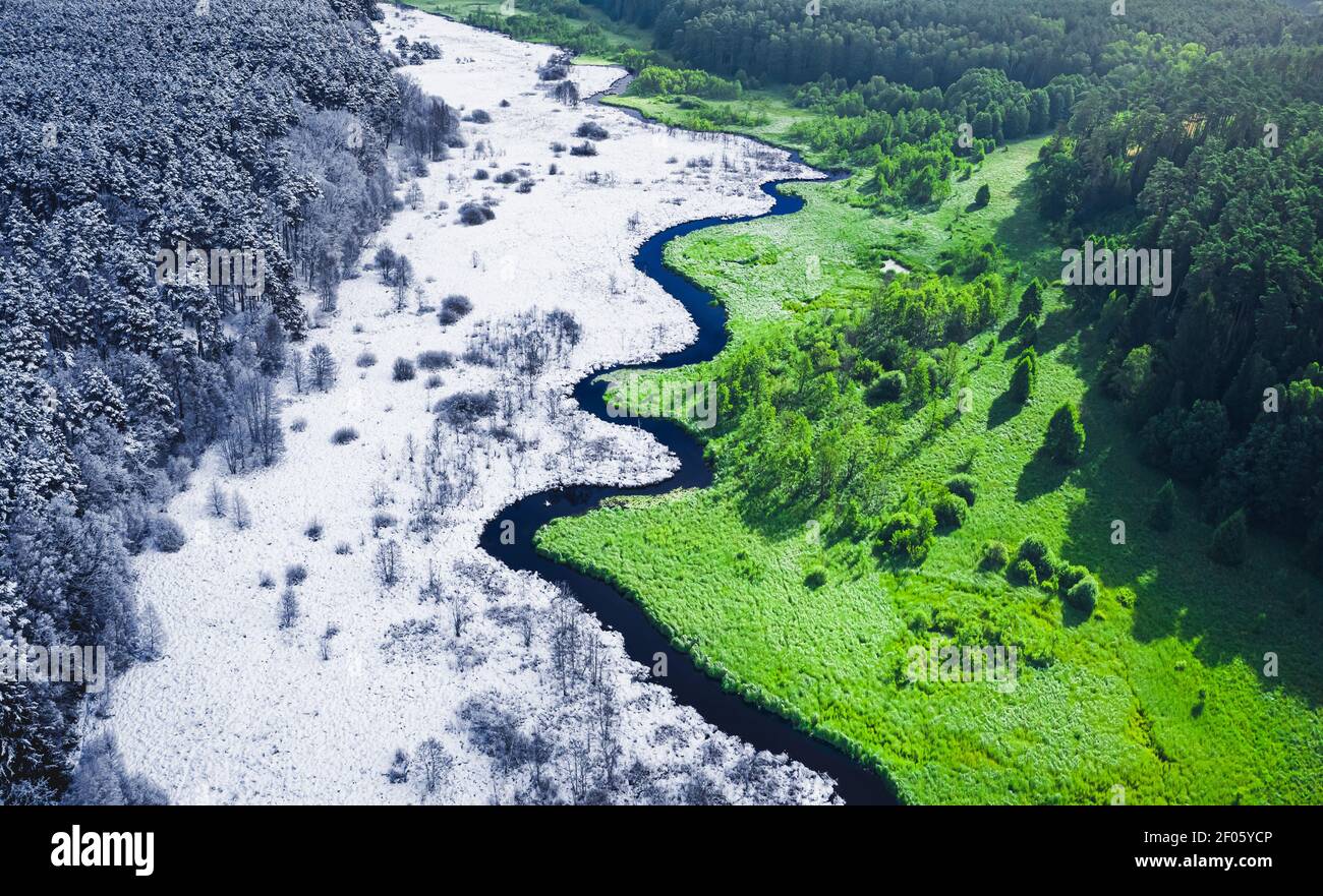 Le printemps arrive. Forêt enneigée et verte. Printemps et hiver en un seul endroit. Vue aérienne Banque D'Images