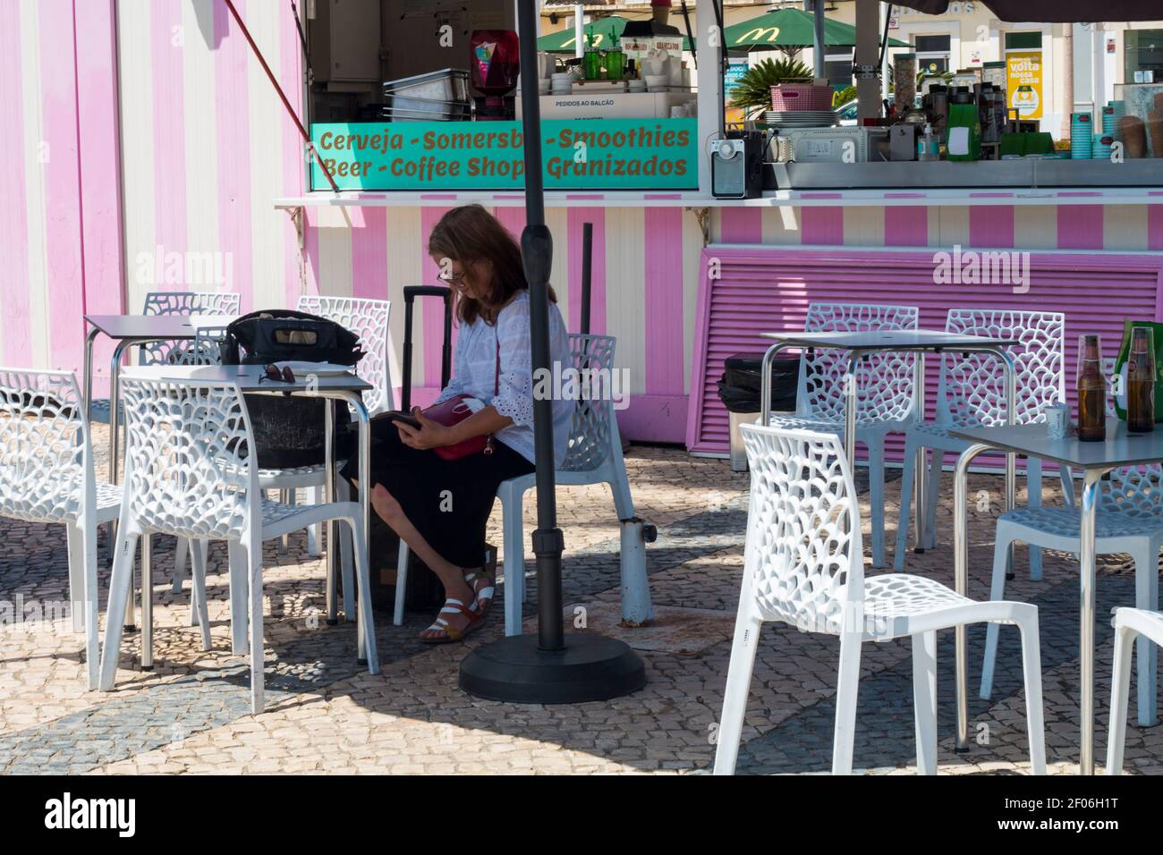 Faro, Portugal - avril 9 2020. Femme se reposant dans un bar chic à côté du port de Faro, en Algarve, en été. Banque D'Images