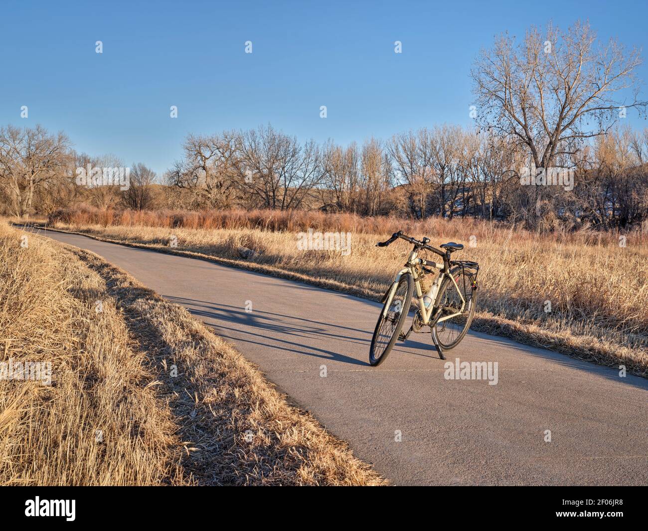 Vélo de tourisme à la fin de l'automne ou paysage d'hiver à la lumière du coucher du soleil sur une piste cyclable près de Windsor, dans le nord du Colorado, concept de loisirs et de déplacement Banque D'Images