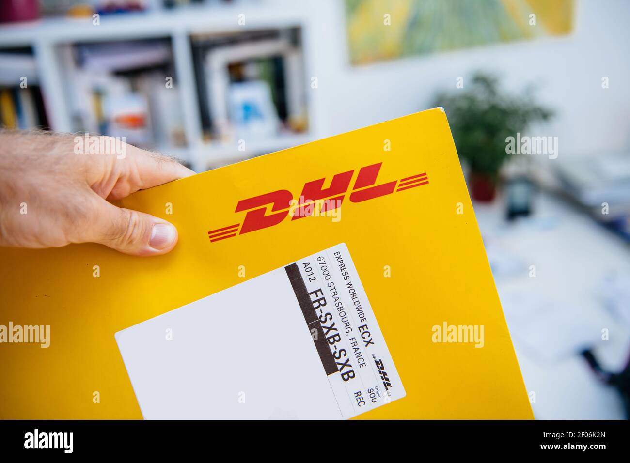 Strasbourg, France - 15 septembre 2018 : POV main mâle tenant le texte sur  l'étiquette d'une enveloppe DHL pour l'entreprise de colis avec le code de  destination SXB Photo Stock - Alamy