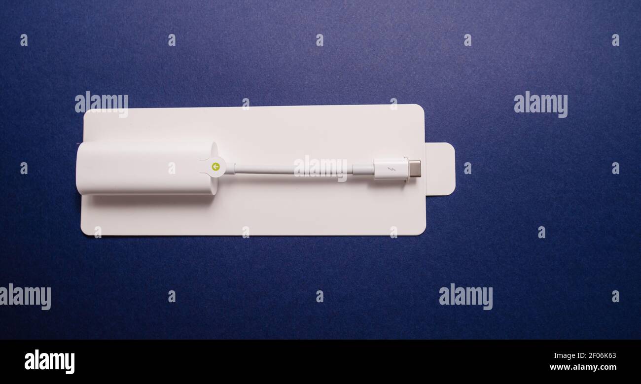 Paris, France - 8 novembre 2018 : vue de dessus de l'adaptateur Thunderbolt 3 à 2 fabriqué par Apple Computers - isolé sur fond bleu - image horizontale Banque D'Images