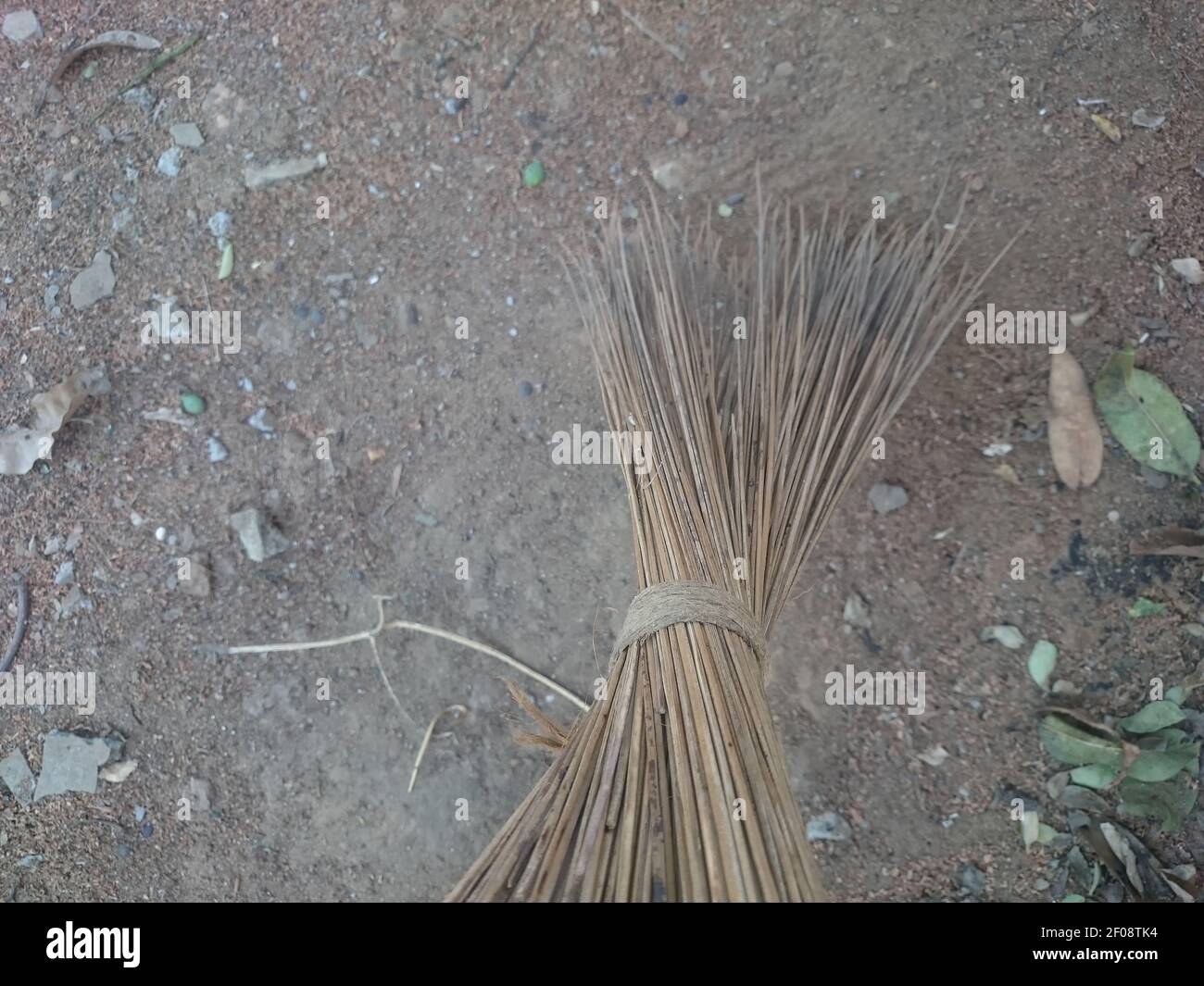Nettoyage au sol avec un balai d'herbe à feuilles de noix de coco. Banque D'Images
