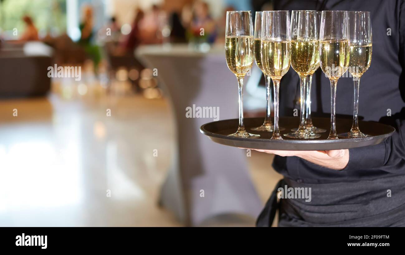 Waiter serving champagne sur un plateau Banque D'Images